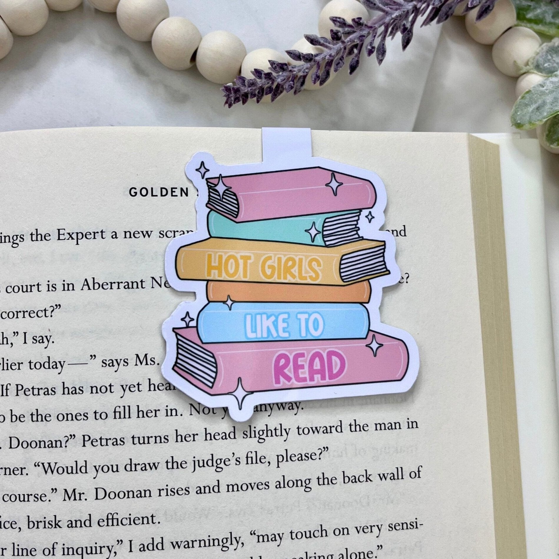 Magnetic bookmark with the phrase 'Hot Girls Read' and an illustration of a stack of books, combining a stylish message with a book-themed design