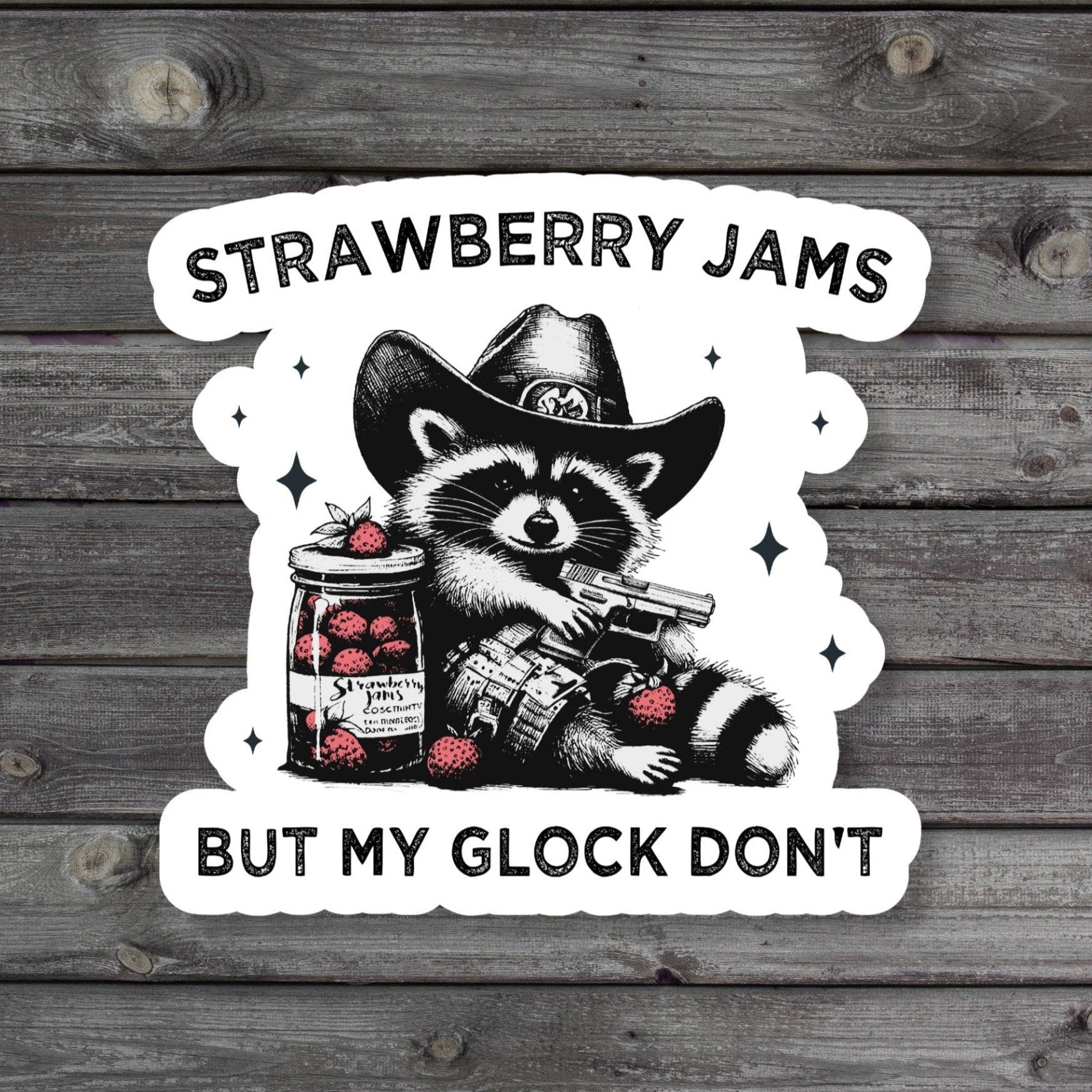 Funny sticker with the text 'Strawberry Jams But My Glock Don't' featuring playful imagery of a raccoon strawberries and a gun